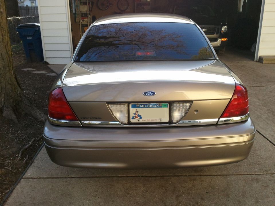 2007 Ford Crown Victoria rear view, Michigan plate, parked in driveway next to garage
