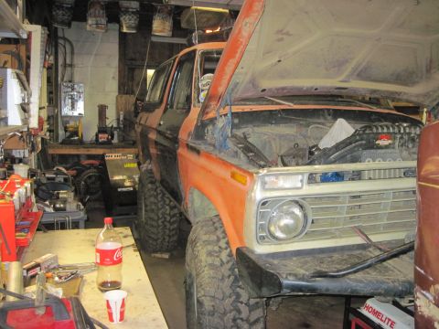 1978 Ford Bronco - 1978 Ford Bronco undergoing work in a garage, hood raised to reveal the engine bay.