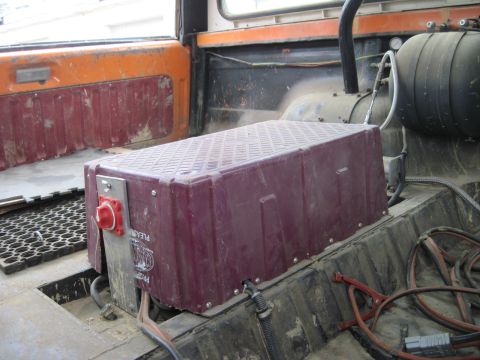 1978 Ford Bronco - A large battery box with a prominent red cutoff switch is installed inside the vehicle's cabin.