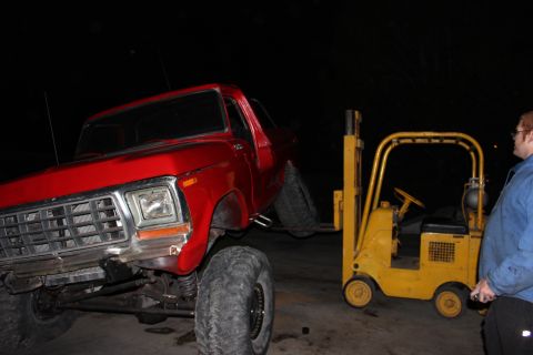 1978 Ford Bronco - A red 1978 Ford Bronco is being lifted by a yellow forklift.