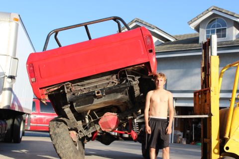 1978 Ford Bronco - A red 1978 Ford Bronco is lifted by a forklift, with a person standing nearby.