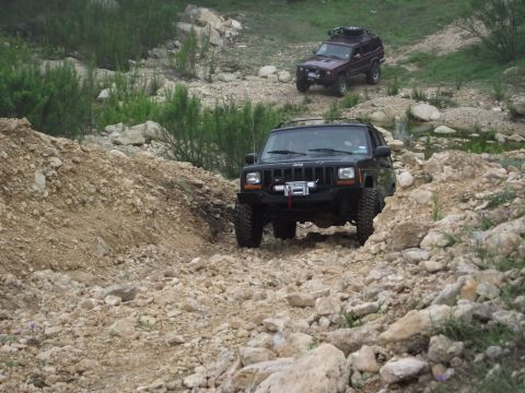 1989 Ford Bronco - Two Jeep Cherokees navigate a rocky off-road trail.