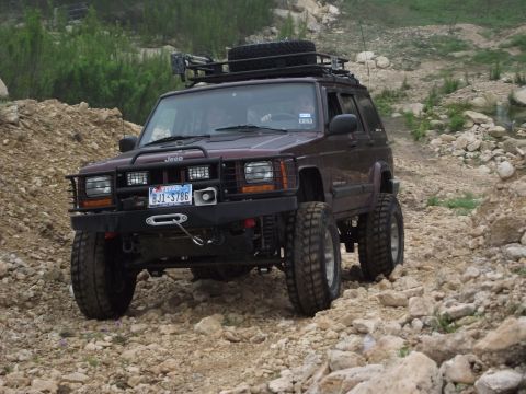 1989 Ford Bronco - This modified Jeep Cherokee XJ navigates a rocky trail, equipped for off-road adventure.