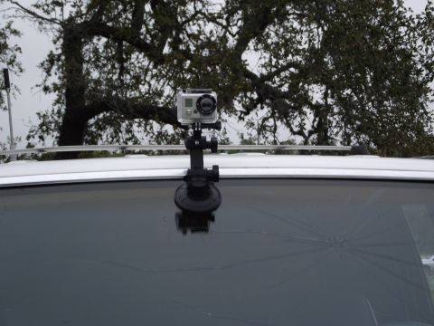 1989 Ford Bronco - A GoPro camera is mounted on a car's windshield, which has a large crack. Trees are visible in the background.