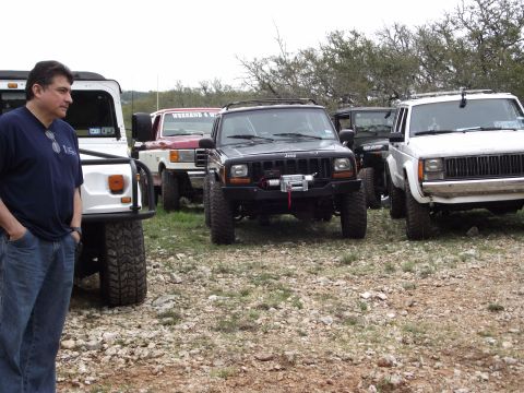 1989 Ford Bronco - A group of off-road vehicles, including Jeeps and a Ford truck, are gathered in an outdoor setting.