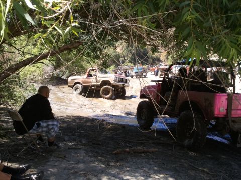 1978 Ford Bronco - Off-road vehicles navigate a muddy trail, with a 1978 Ford Bronco prominently featured.