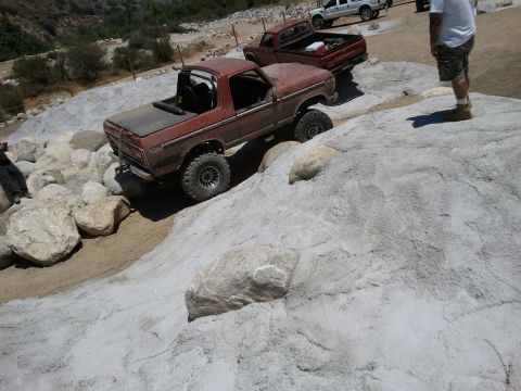 1978 Ford Bronco - This lifted 1978 Ford Bronco navigates a rocky incline, with other trucks visible in the background.
