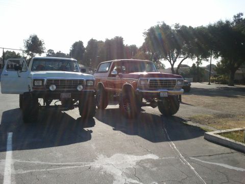 1978 Ford Bronco - Two classic Ford trucks, a pickup and a Bronco, are parked outdoors on a sunny day.