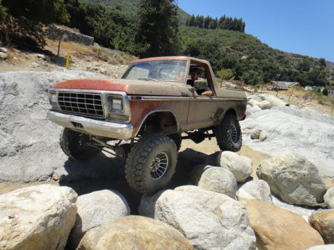 1978 Ford Bronco - A 1978 Ford Bronco tackles a challenging rocky trail, its lifted suspension and aggressive tires providing traction.