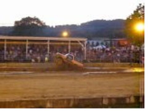 1978 Ford Bronco - A truck participates in a mud bogging event with a crowd watching from bleachers.