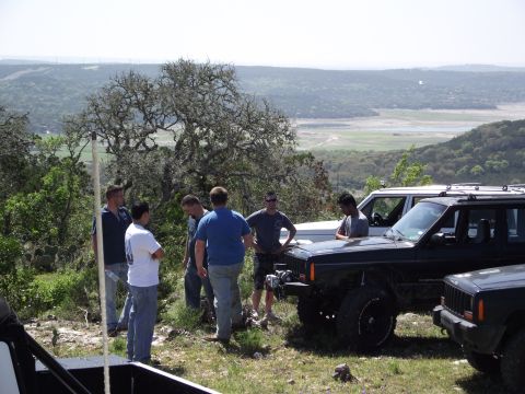 1989 Ford Bronco - Group of people gathered around multiple Jeep Cherokees on a scenic overlook.