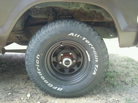 1979 Ford Bronco - Close-up of a vehicle's wheel and fender, revealing rust on the undercarriage.