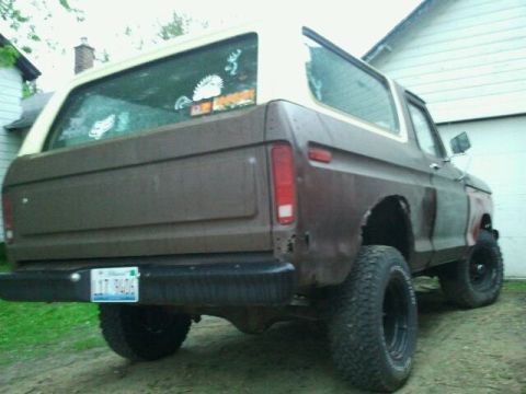 1979 Ford Bronco - This 1979 Ford Bronco is viewed from the rear quarter, showing its brown body and white top, with an Illinois license plate visible.