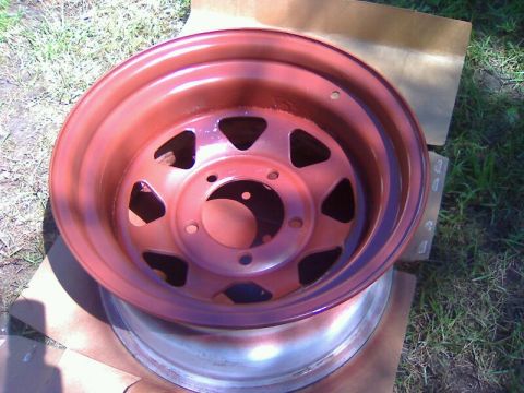1979 Ford Bronco - A red painted steel wheel is shown, likely undergoing restoration or modification.