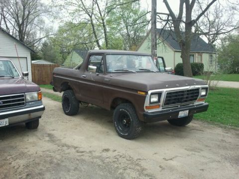 1979 Ford Bronco - A brown 1979 Ford Bronco is parked next to another vehicle.