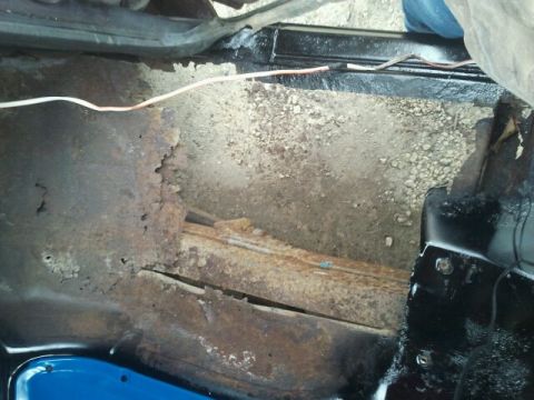1979 Ford Bronco - Interior floor pan shows significant rust damage and exposed wiring.