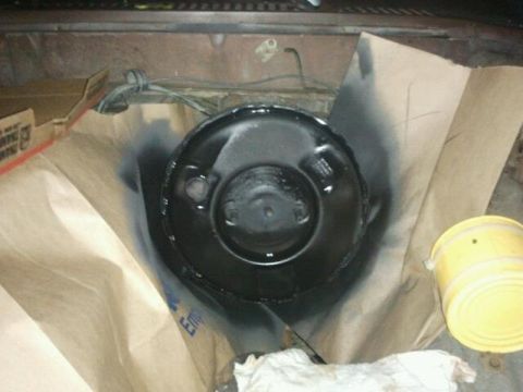 1979 Ford Bronco - Brake booster being painted, with brown paper and a yellow container nearby.