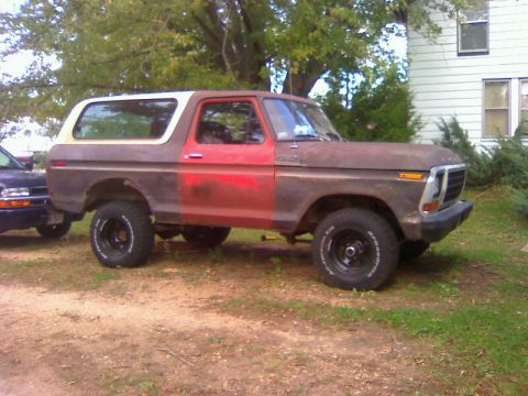 1979 Ford Bronco - This weathered 1978 Ford Bronco sits on a dirt lot, showing signs of rust and a two-tone paint job.