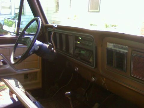 1979 Ford Bronco - The interior of a 1979 Ford Bronco shows a brown dashboard, steering wheel, and radio.