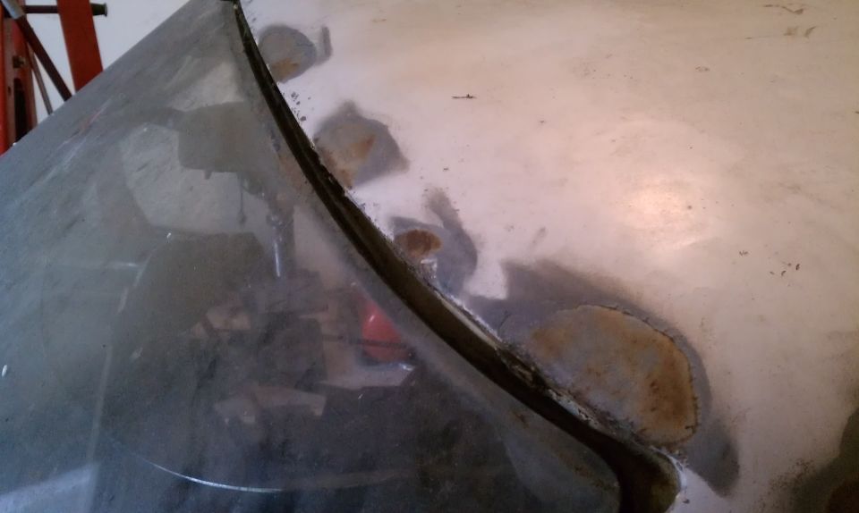 Few small surface rust patches along the windshield on the driver side.