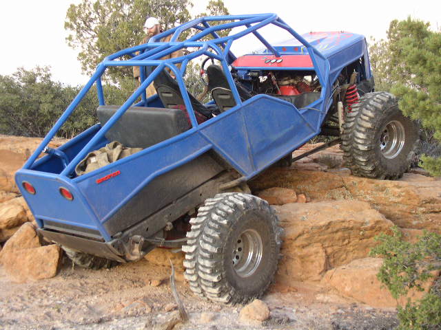 Blue tube-chassis rock buggy crawling red sandstone ledges on big tires
