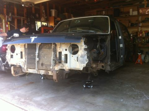 1989 Ford Bronco - Front end of a 1989 Ford Bronco disassembled for work in a garage setting.