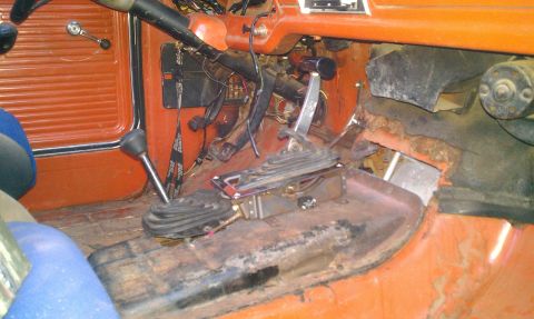 1969 Ford F-250 - Interior view of a truck cabin, dual shifters and orange-colored door panels.