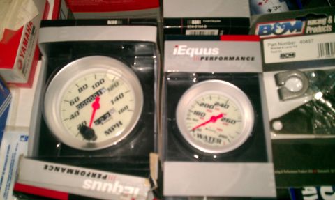1969 Ford F-250 - Two new Equus performance gauges, a speedometer and a water temperature gauge, are displayed in their packaging.