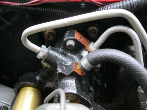 1978 Ford Bronco - This image shows a close-up of an engine component with attached hoses and metal lines.