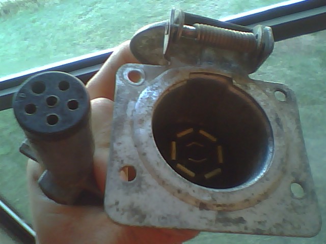 Trailer hitch connector and plug held in hand