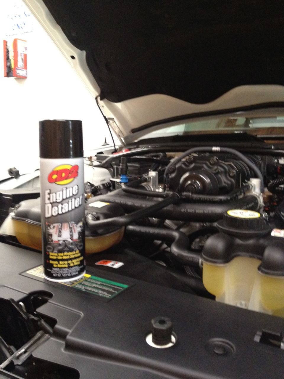Engine bay with a can of engine detailer spray. Hood is open