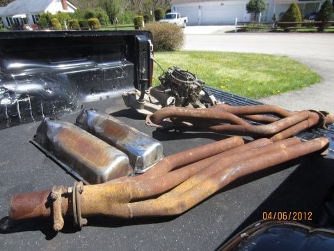 1979 Ford Bronco - Engine manifold and valve covers are pictured in the bed of a pickup truck.
