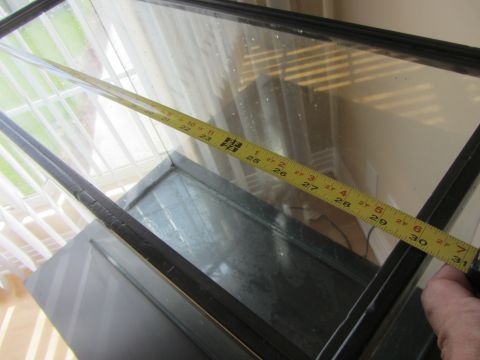 1968 Ford Mustang - A yellow measuring tape is laid across a glass tank, indicating a length of approximately 30 inches.