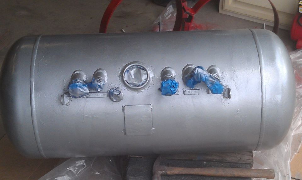 Silver propane tank with multiple fittings, some covered in blue tape