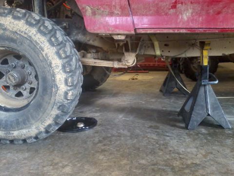1995 Ford F-150 - Truck frame and suspension parts visible while on jack stands in a garage.
