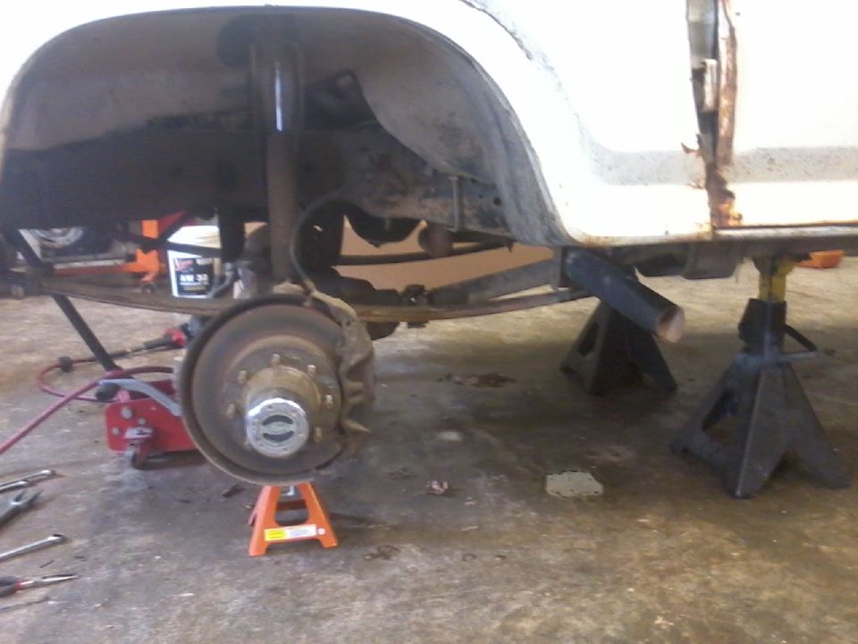 Truck rear axle and suspension on jack stands, showing leaf springs and brake assembly