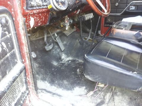 1978 Ford Bronco - The interior of a vehicle shows wear and tear on the floor and dashboard.
