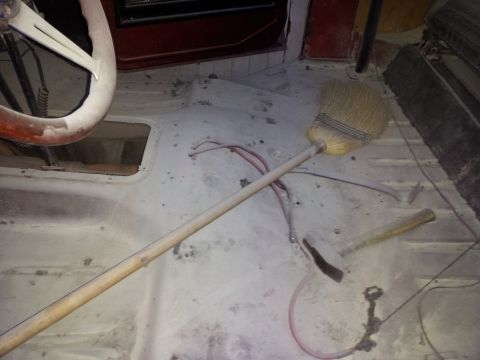 1978 Ford Bronco - Tools and a steering wheel are on the floor of a vehicle's interior.