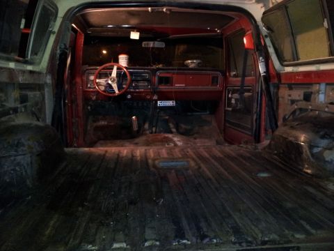 1978 Ford Bronco - The interior of a classic SUV, a red dashboard and an open cargo space.