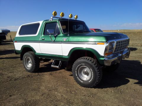 1979 Ford Bronco - This lifted green and white Ford Bronco features custom smiley face lights on its roof rack and BFGoodrich Mud-Terrain tires.