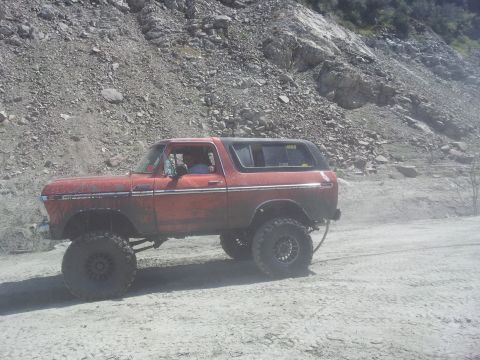 1978 Ford Bronco - 1978 Ford Bronco navigating a dusty, rocky terrain off-road.
