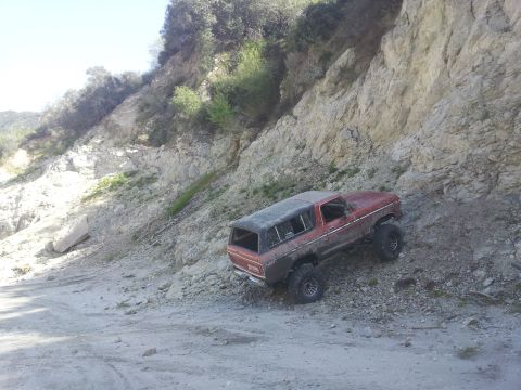 1978 Ford Bronco - A red 1978 Ford Bronco navigates a steep, rocky trail.