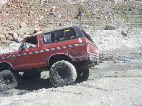 1978 Ford Bronco - This red 1978 Ford Bronco is stuck in the mud, being pulled by a cable.