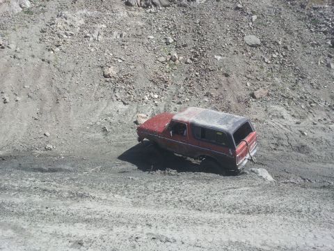 1978 Ford Bronco - This 1978 Ford Bronco appears to be stuck in mud on a challenging, rocky terrain.