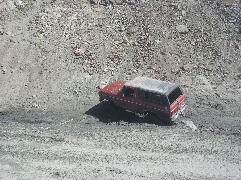 1978 Ford Bronco stuck in mud on a steep, rocky incline
