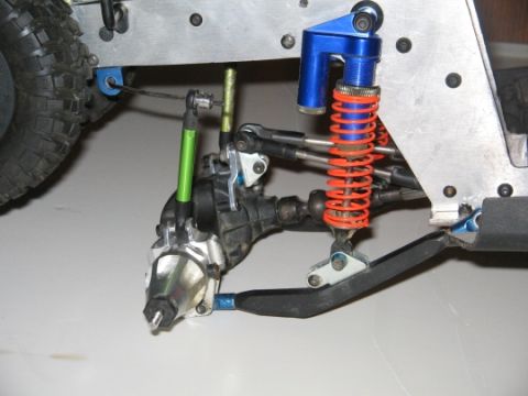 1986 Ford Bronco - Close-up of a remote control car's suspension system, showing the shock absorber and drive axle.
