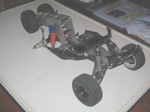 1986 Ford Bronco - The chassis of a remote control car is shown from a high angle, revealing its internal mechanical parts.