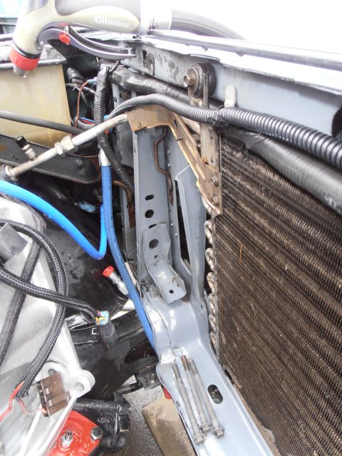 1990 Ford Bronco - Engine bay detail showing radiator, hoses, and mounting hardware.