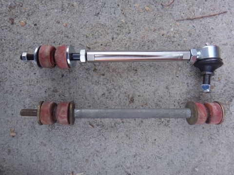 1995 Ford Taurus - Comparison of a new chrome stabilizer link next to an older gray one on a concrete surface.