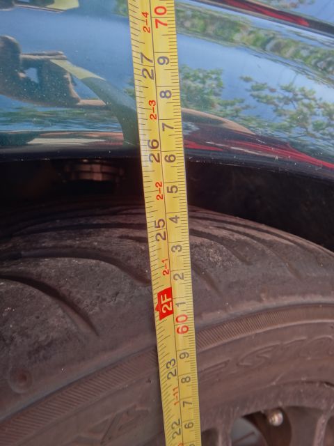 1995 Ford Taurus - Measuring the distance from the tire to the fender well.